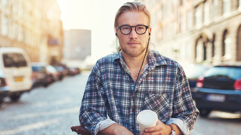 Man står vid sin cykel med kaffemugg i handen.